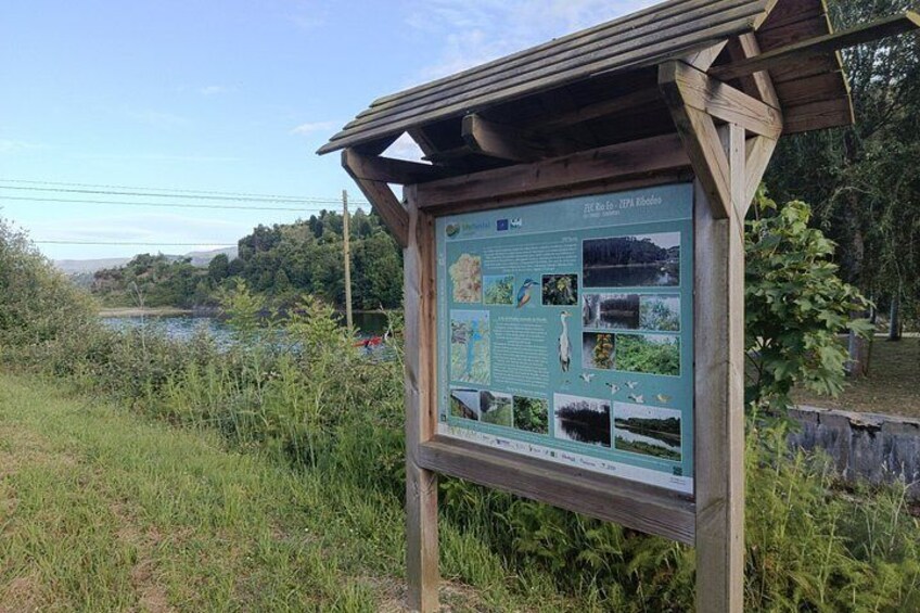 A wooden information board with maps and wildlife photos. 3