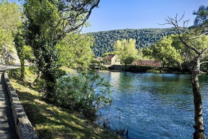 A river, a stone bridge, and a house by the water. 2