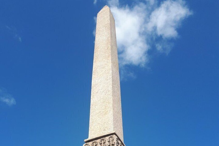 A tall, narrow obelisk against a clear blue sky. 5