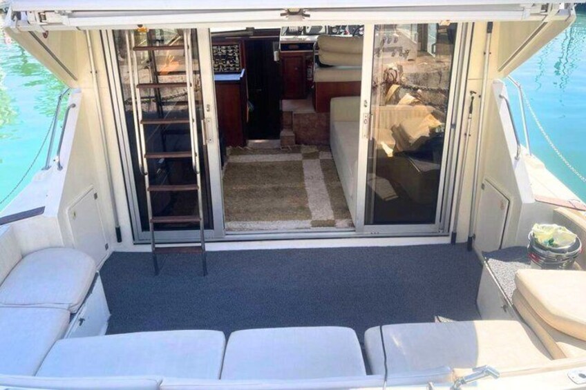 A boat interior with a sliding door, a ladder, and a small kitchen area. 2