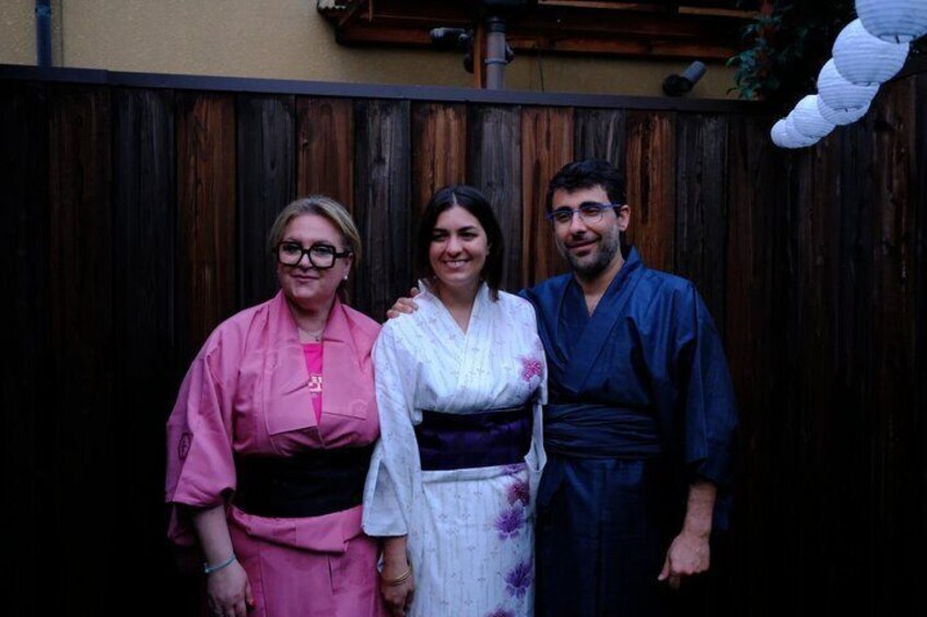 Three people standing in front of a wooden fence. 3