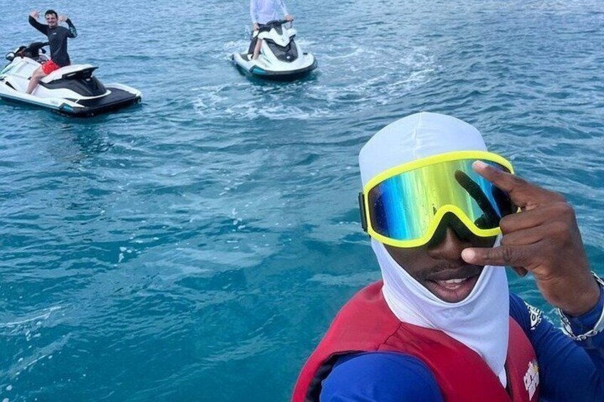 A person on a jet ski, another on a watercraft, and a third person in the background. 3
