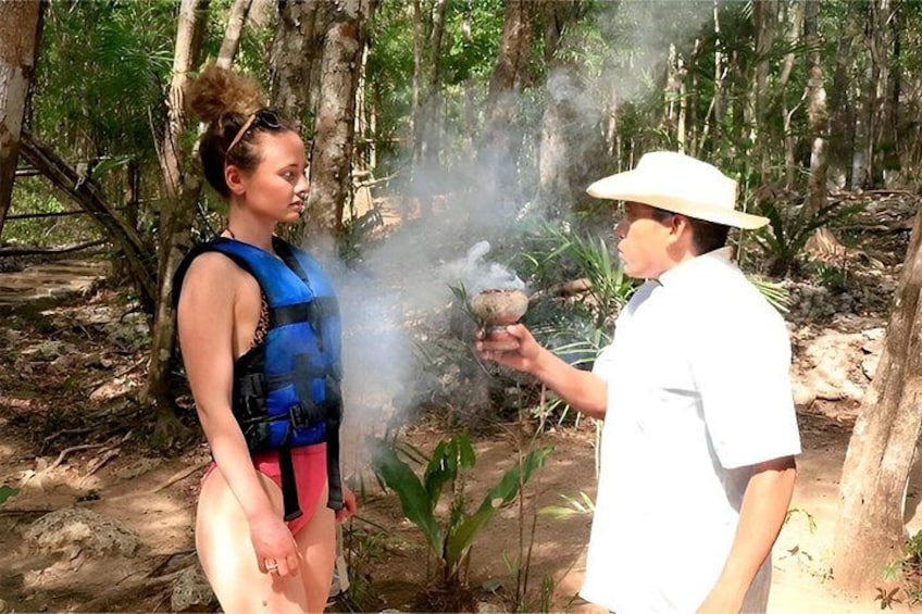 Two people in a forest, one holding a smoke-emitting object. 2