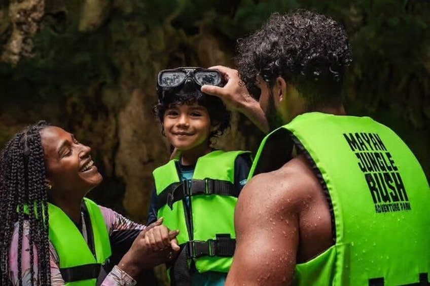 People wearing bright green life vests with the text 'Maya Jungle Rush Adventure Park' on them. 4