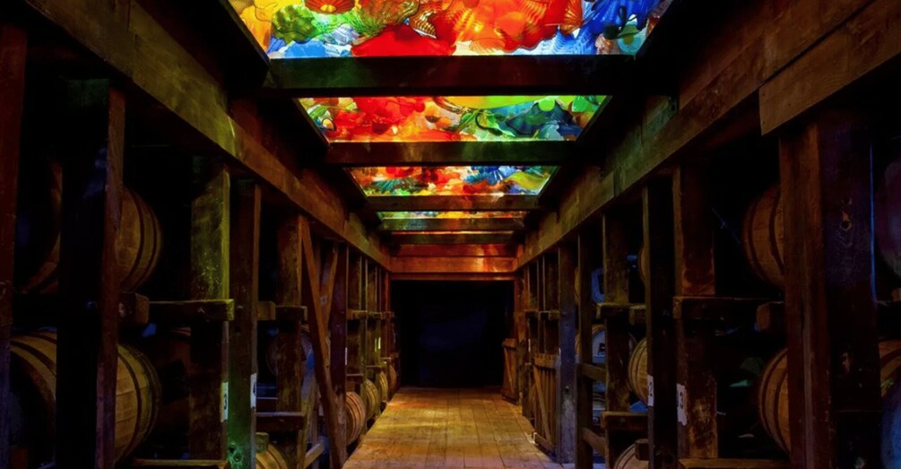 A wooden barrel room with a colorful stained glass ceiling. 2