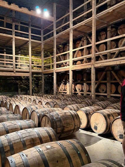 Wooden wine barrels stacked in a warehouse with a wooden ceiling and beams. 5