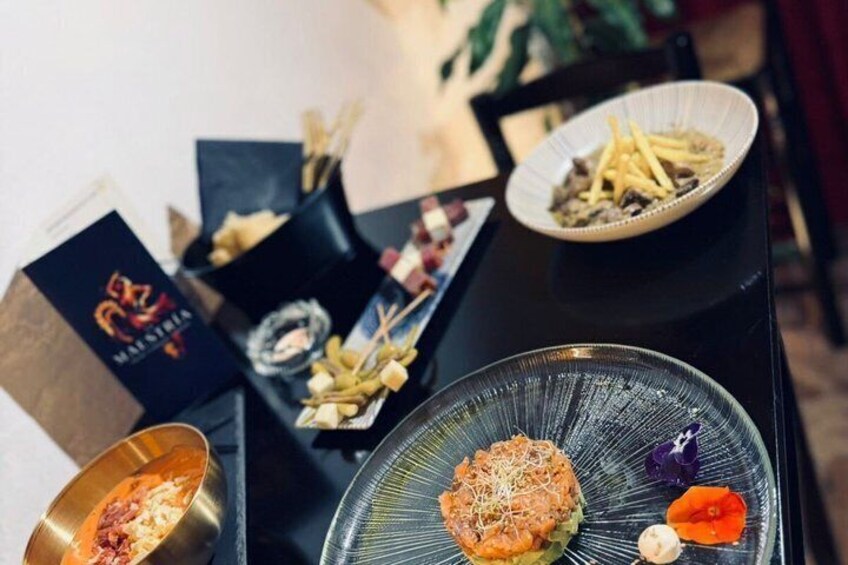 A table with various dishes, including a bowl of soup, a plate of fries, and a dessert. 1