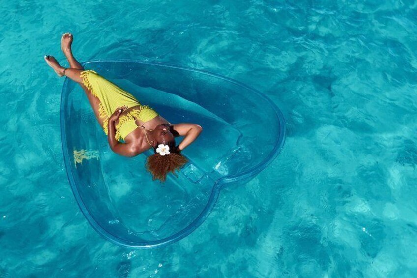 A person floating in a clear blue pool wearing a yellow swimsuit. 5