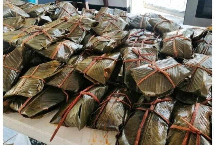 A large number of food items wrapped in leaves and tied with strings. 1