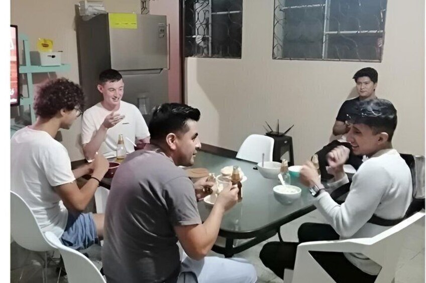A group of people sitting around a table, eating and conversing. 5