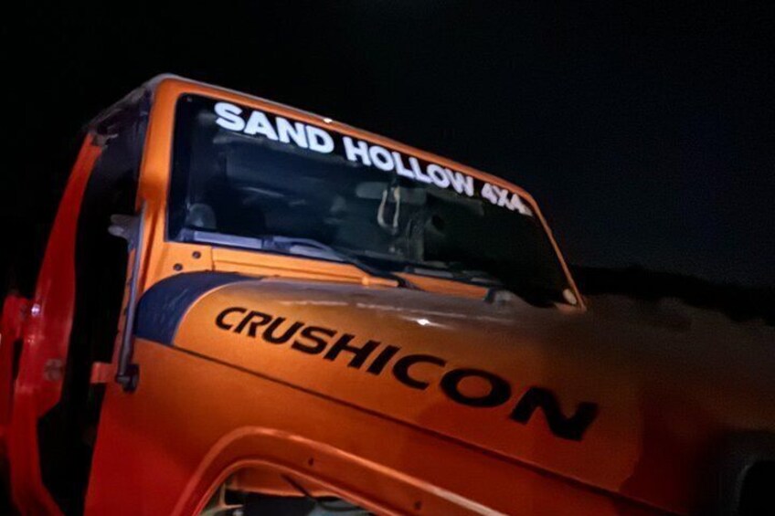 A large orange vehicle with 'CRUSHICON' and 'SAND HOLLOW 4X4' written on it. 3