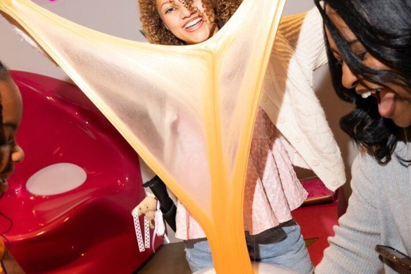 A person holding a yellow and white striped fabric, a red object, and a white object. 2