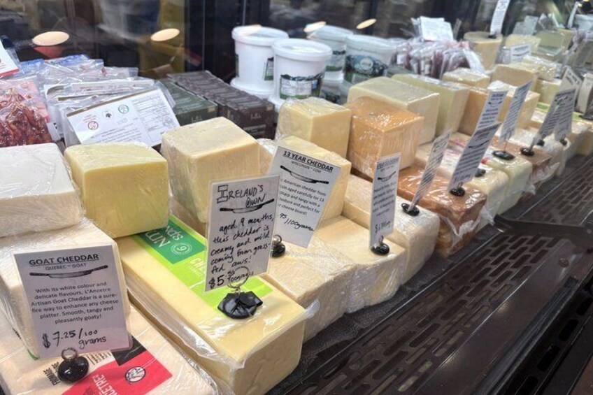 A variety of cheeses on display in a shop window. 3