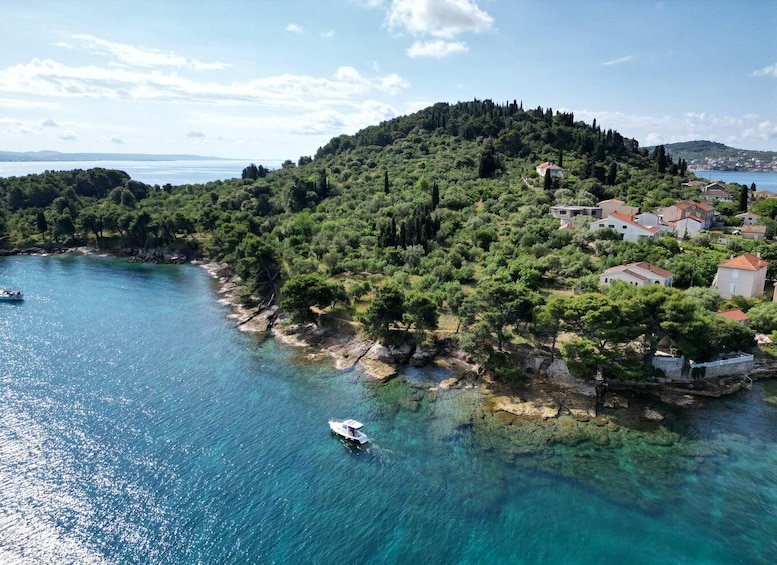 A coastal village with clear turquoise waters, boats, and lush greenery. 4
