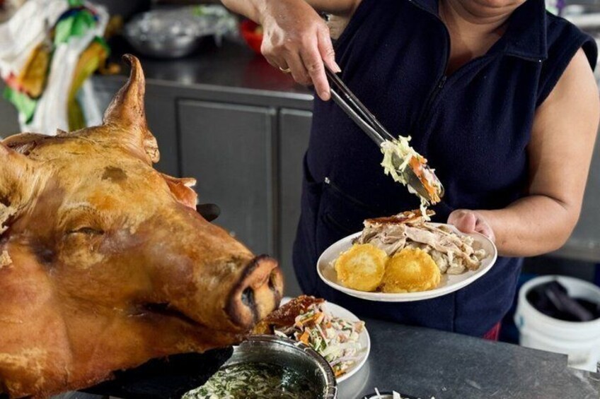 A person serving food from a large roasted pig. 5