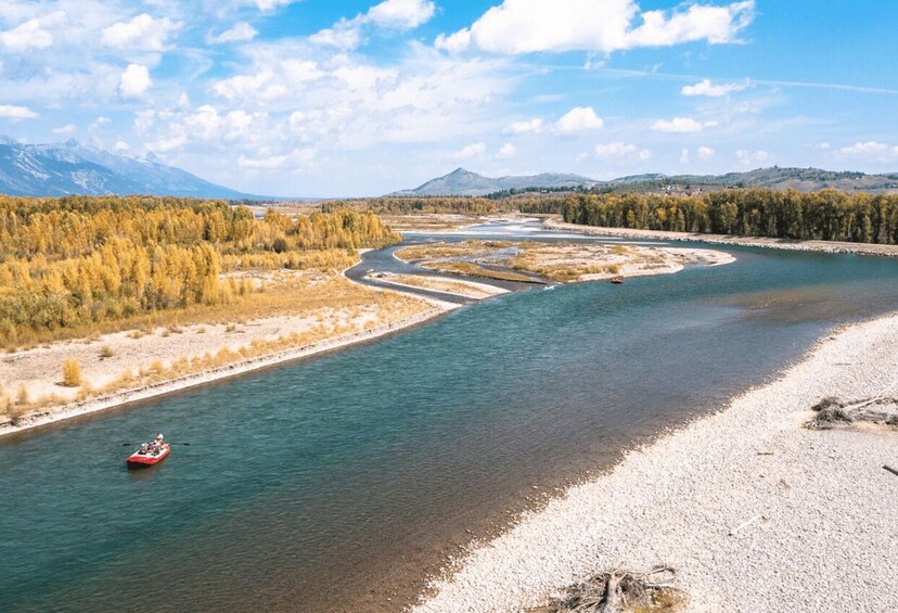 A river with a boat, surrounded by forest and mountains. 3