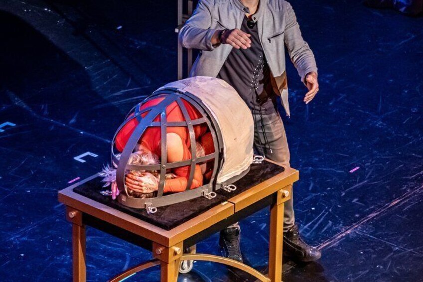 A person standing next to a table with a spherical object on top. 2