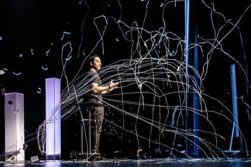 A person on stage with abstract light trails. 3