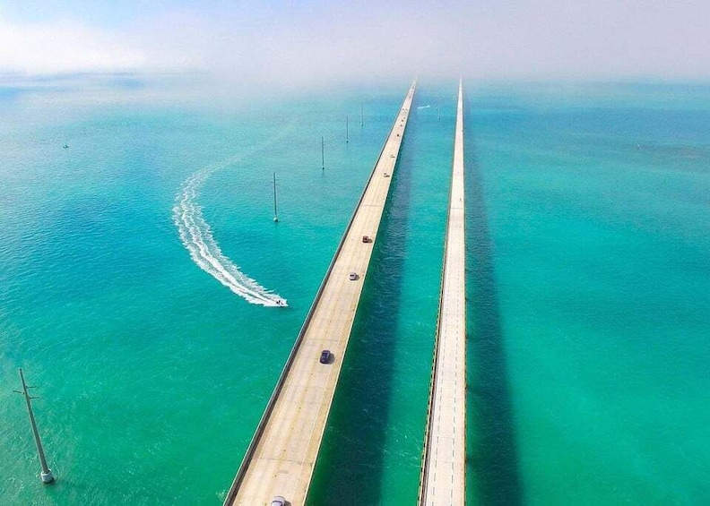 A long bridge over turquoise water with a clear sky. 1
