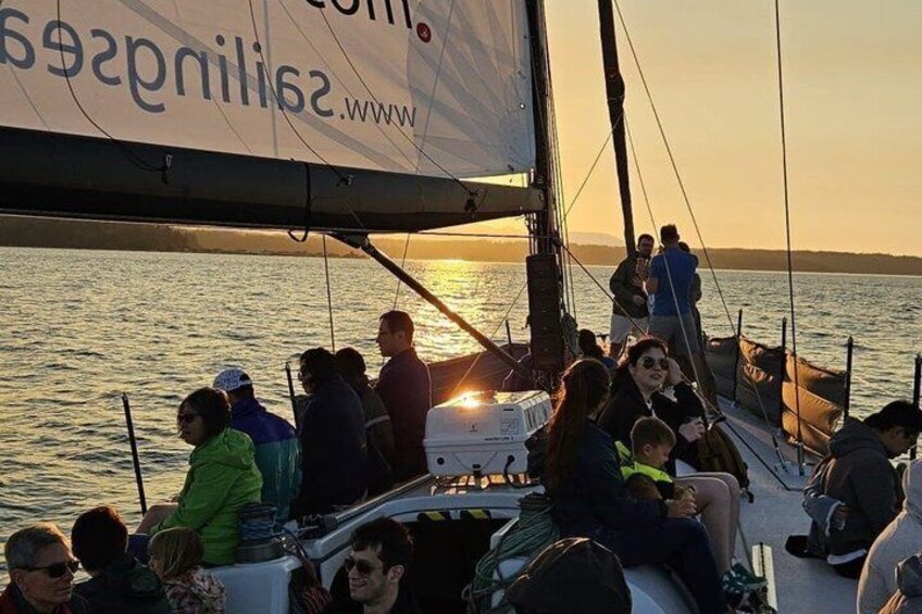 A sailboat with people on board during sunset. 5