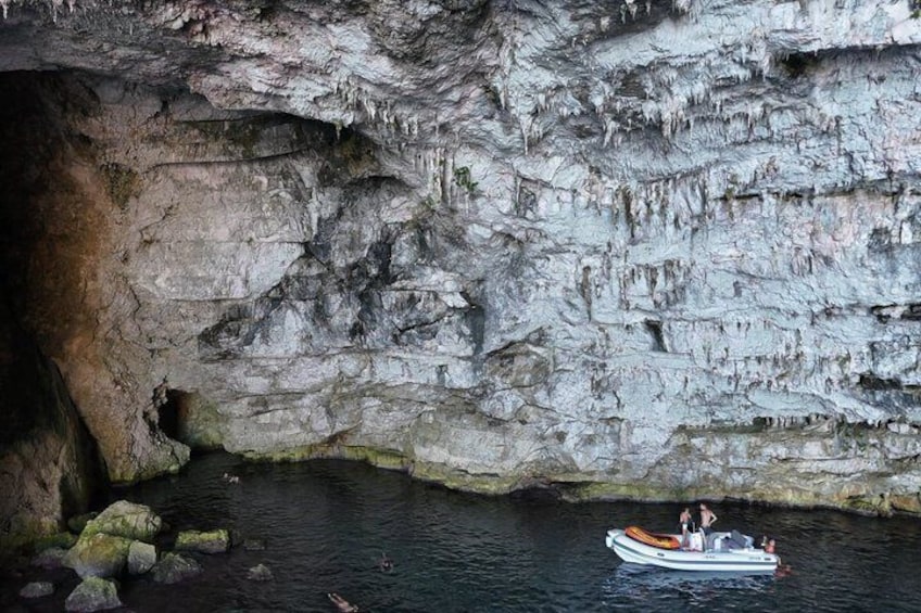 A boat on a calm river with rocky cliffs in the background. 5