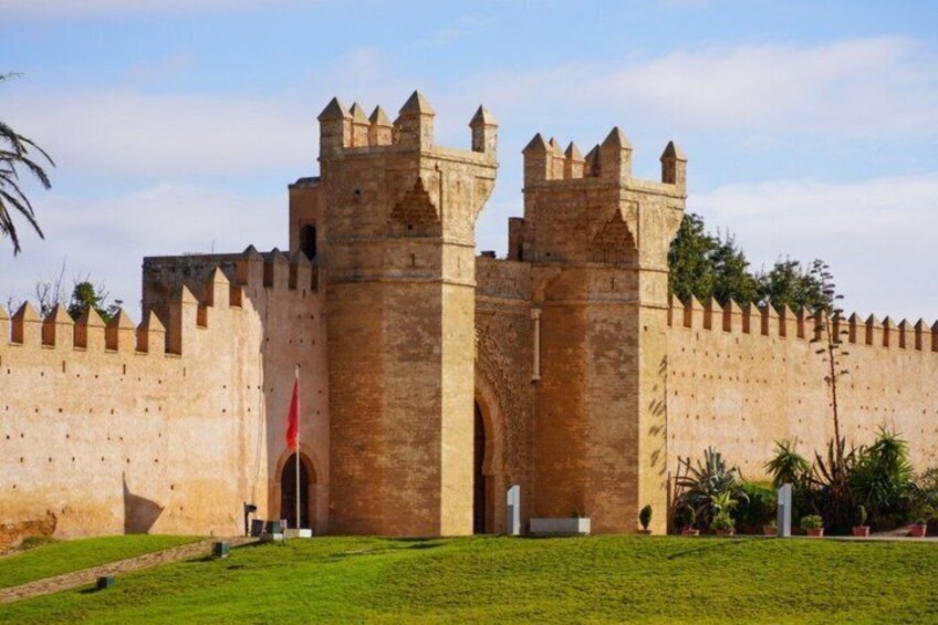 A historic stone fortress with crenellated walls and two prominent towers. 1