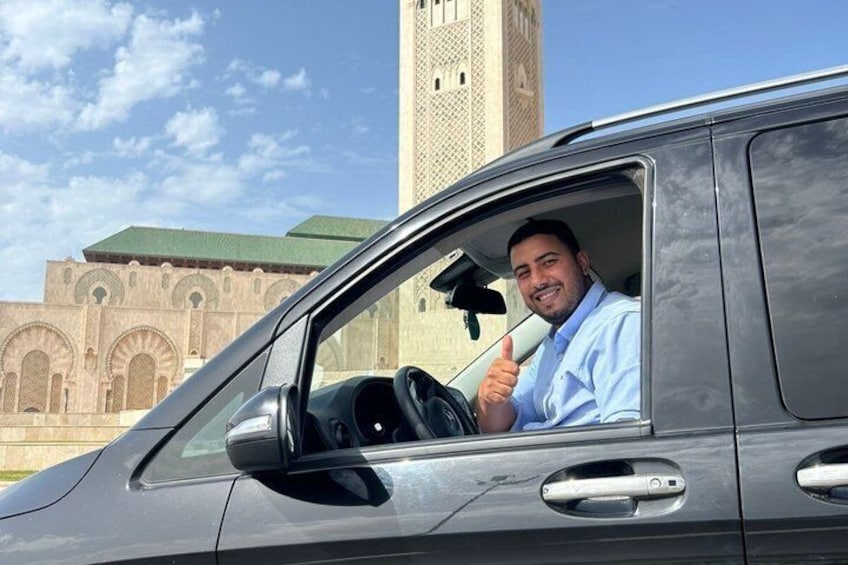 A person in a car with a building in the background. 3