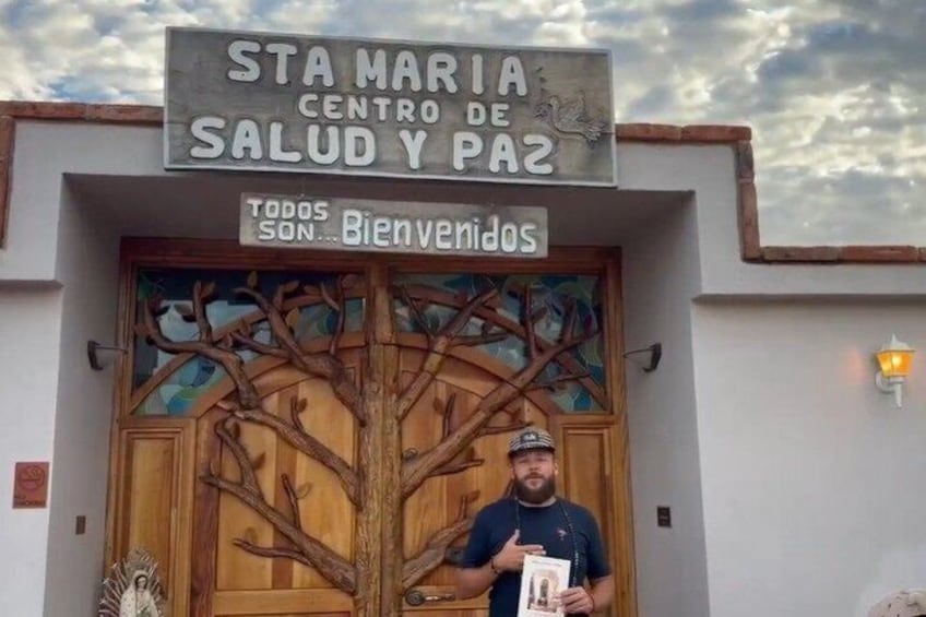 A building entrance with a sign reading 'STA MARIA CENTRO DE SALUD Y PAZ' and a welcome sign. 4