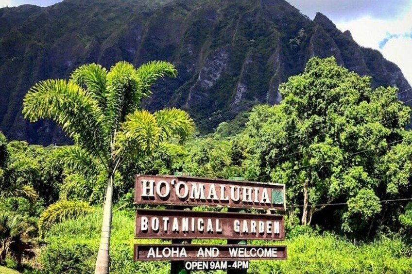 Schild für den Ho'Omaluahia Botanischen Garten mit einer gebirgigen Kulisse. 3