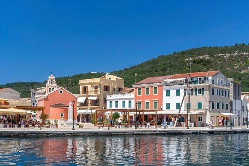 A waterfront town with colorful buildings, a church, and a hill in the background. 2