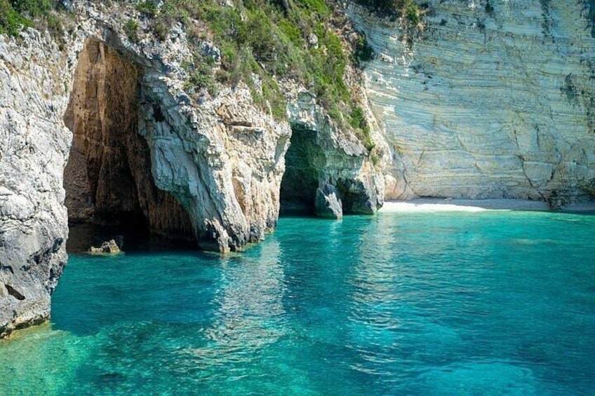 A coastal cave entrance with clear turquoise water. 4