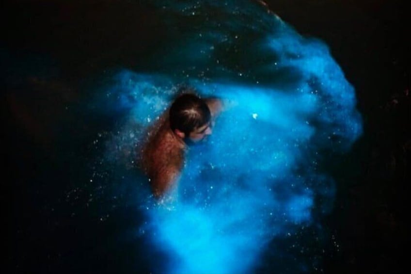 A person swimming in water with a blue light effect. 1