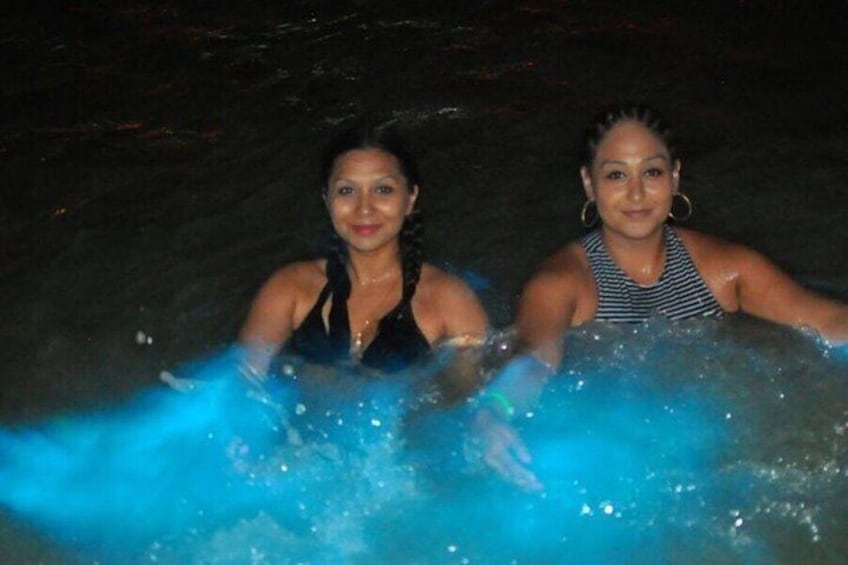Two people in a body of water, possibly a pool or a natural water body, with splashing water around them. 3