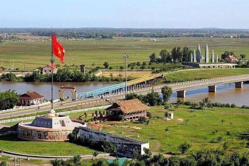 A river with a bridge, a flag, and a monument. 2