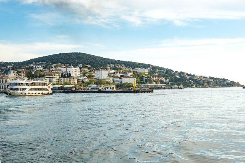 A river with a boat, a pier, and a hillside with buildings. 1