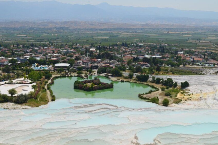 A town with a central green lake, terraced fields, and distant mountains. 5