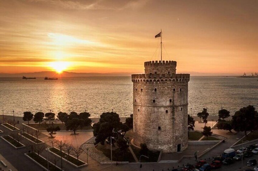 A historic tower by the sea at sunset. 1