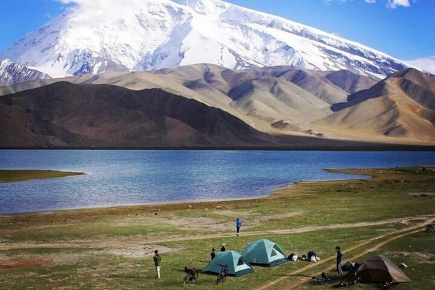 A lake with tents and people, a snow-capped mountain in the background. 5