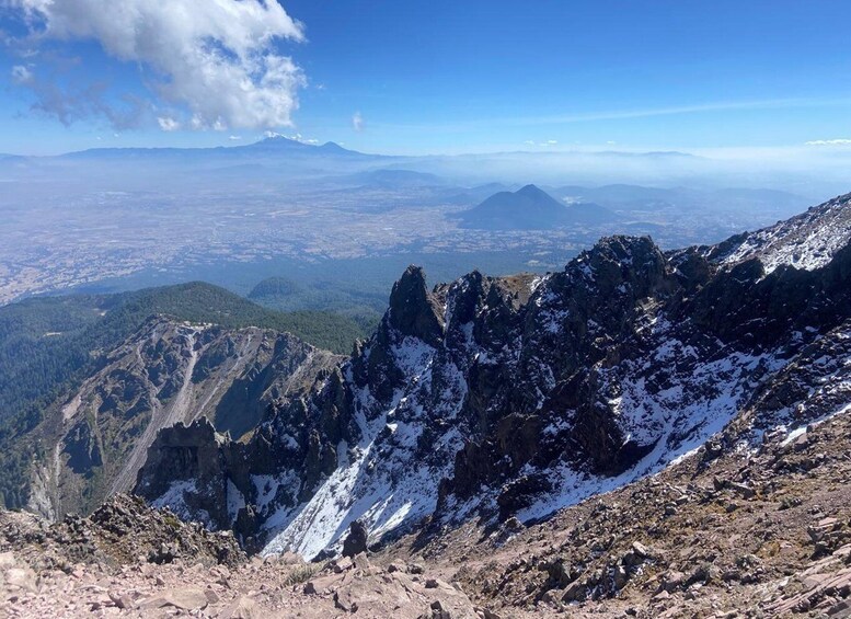 A mountainous landscape with snow-covered peaks and a distant cityscape. 3