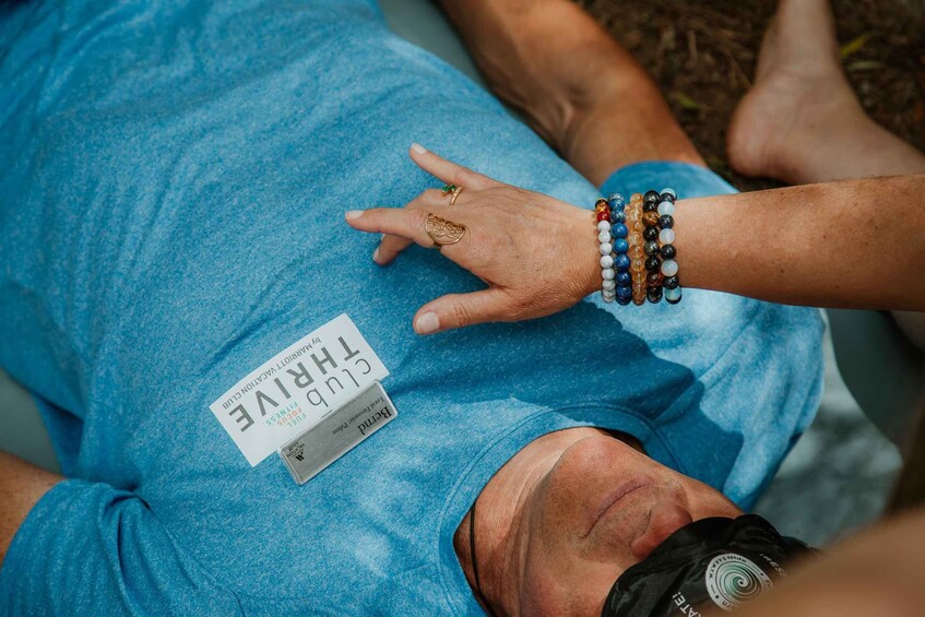A person lying on the ground wearing a blue shirt with a name tag. 2