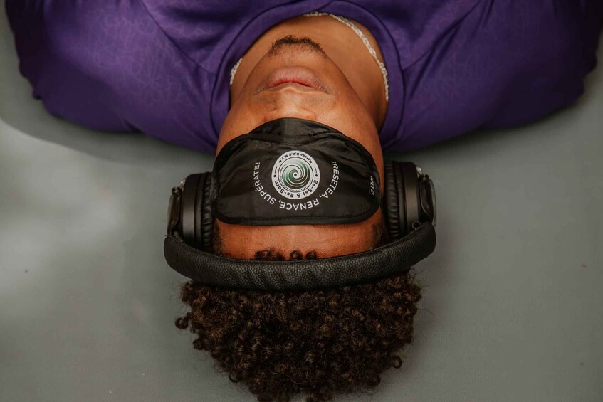 A person lying down with headphones on their head. 5