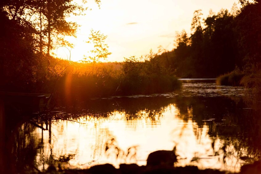 A sunset over a calm river with trees reflecting the light. 5