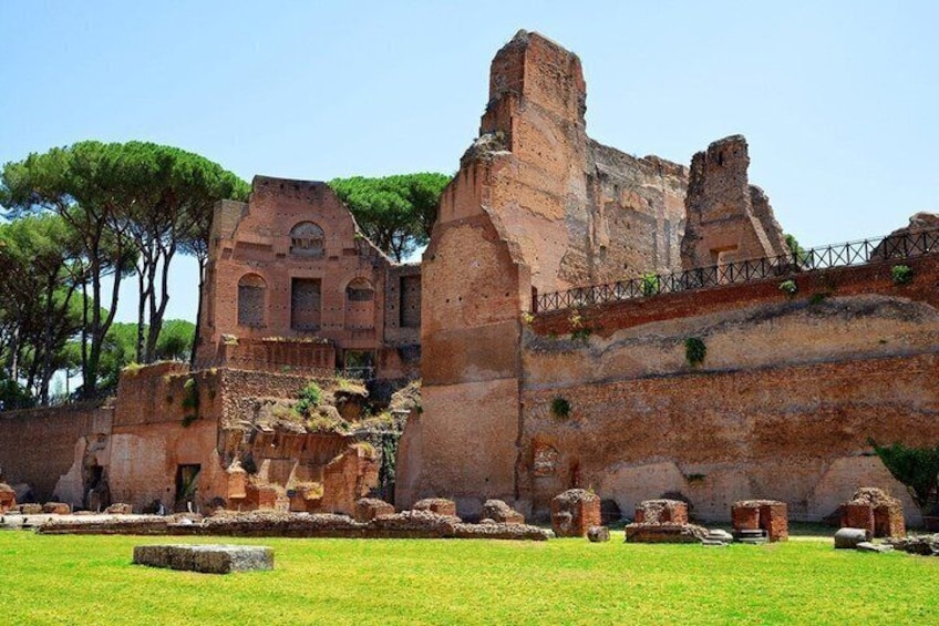 Ancient ruins with intact walls and scattered stones, surrounded by a well-maintained grassy area. 2