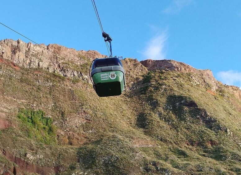 A cable car suspended by a cable against a mountainous backdrop. 5