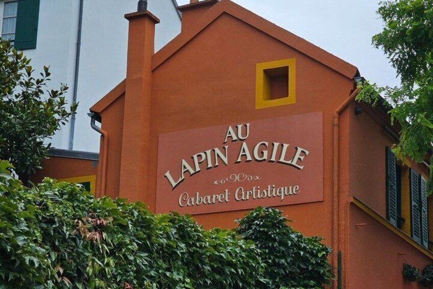 A building with a sign that reads 'AU LAPIN AGILE' and 'Cabaret Artistique.' 5