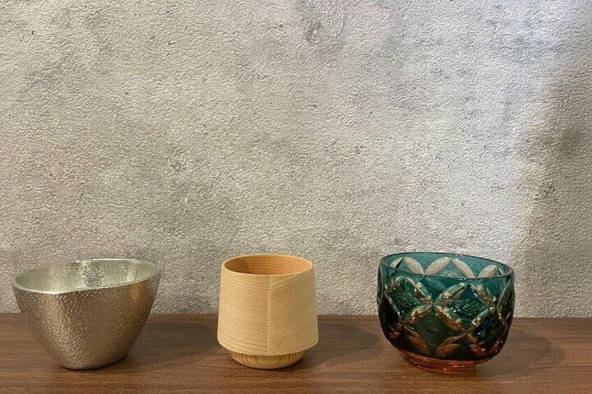 Three ceramic bowls on a wooden surface against a textured wall. 5