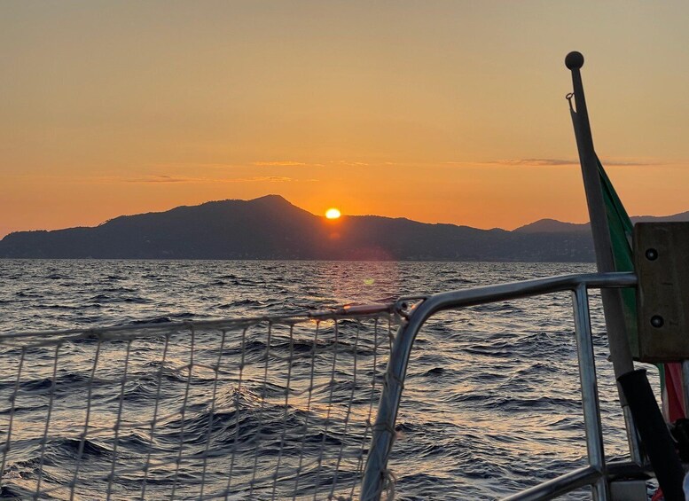 A sunset over the ocean with mountains in the background. 5
