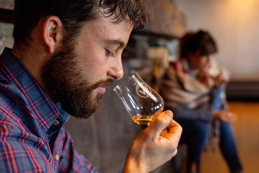 A person holding a glass of whiskey. 5