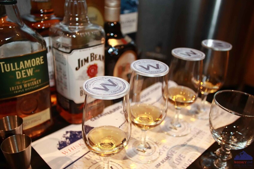 Bottles of whiskey and glasses on a table. 3