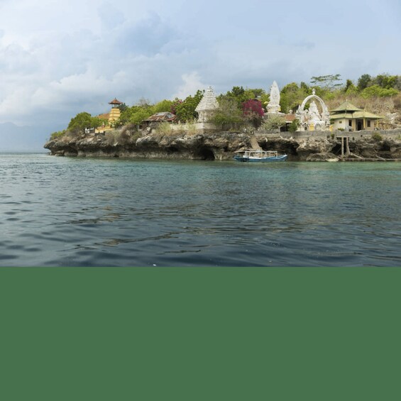 A rocky island with traditional architecture and a boat on the water. 3